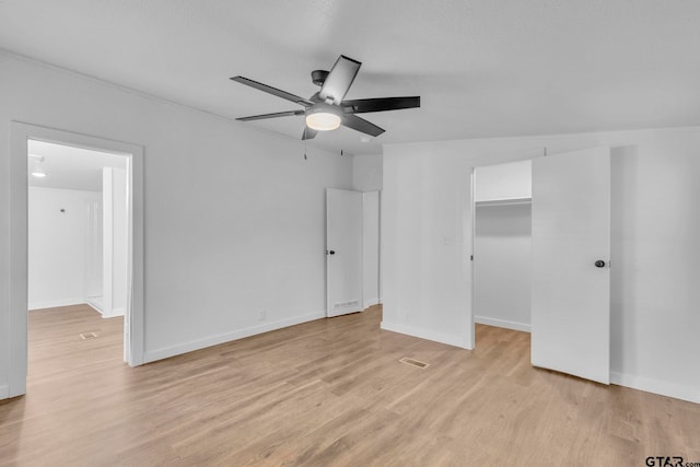 441 N Hill, Tyler, TX 75706 - unfurnished bedroom with light wood-style flooring, a spacious closet, a ceiling fan, and a closet