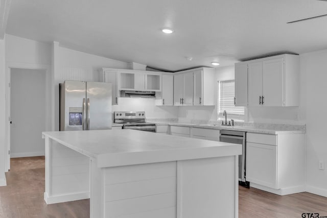 441 N Hill, Tyler, TX 75706 - kitchen with appliances with stainless steel finishes, under cabinet range hood, a center island, wood finished floors, and recessed lighting