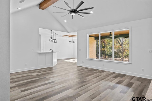 unfurnished living room featuring beamed ceiling, light hardwood / wood-style floors, high vaulted ceiling, and ceiling fan