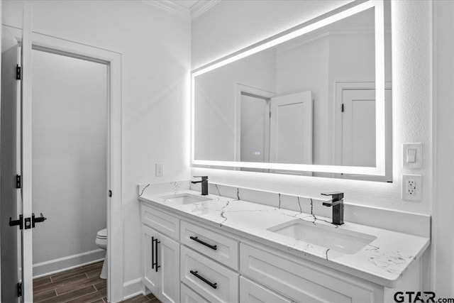 bathroom featuring vanity, toilet, and crown molding