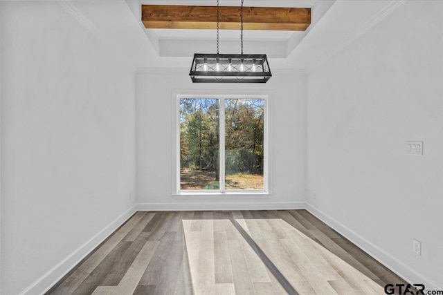 unfurnished dining area with beamed ceiling, hardwood / wood-style floors, and a tray ceiling