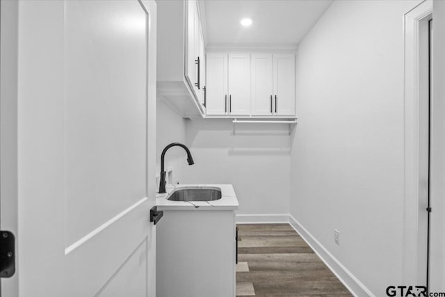 laundry room with hardwood / wood-style floors and sink