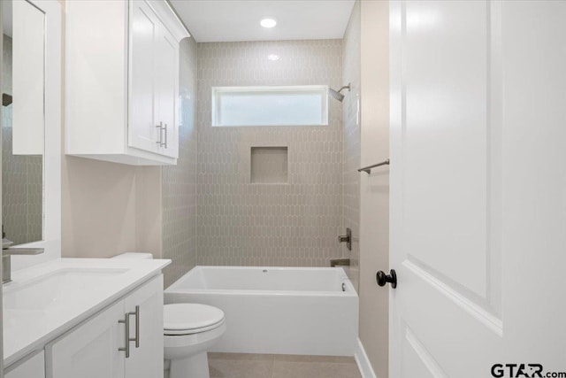 full bathroom featuring tiled shower / bath, vanity, toilet, and tile patterned flooring