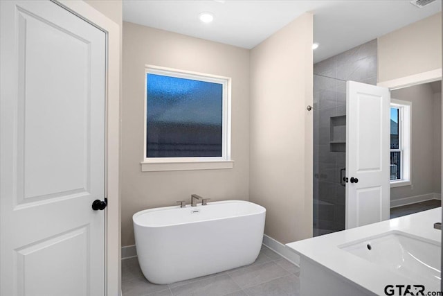 bathroom featuring tile patterned flooring, plus walk in shower, and vanity