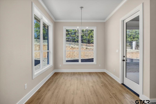 unfurnished dining area featuring crown molding, a notable chandelier, and light hardwood / wood-style floors