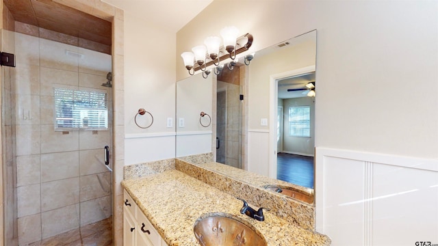 bathroom featuring vanity, hardwood / wood-style flooring, a shower with door, and ceiling fan