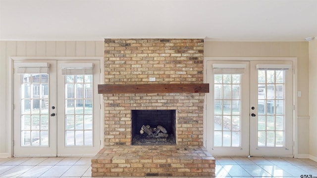 unfurnished living room featuring french doors, a brick fireplace, and plenty of natural light