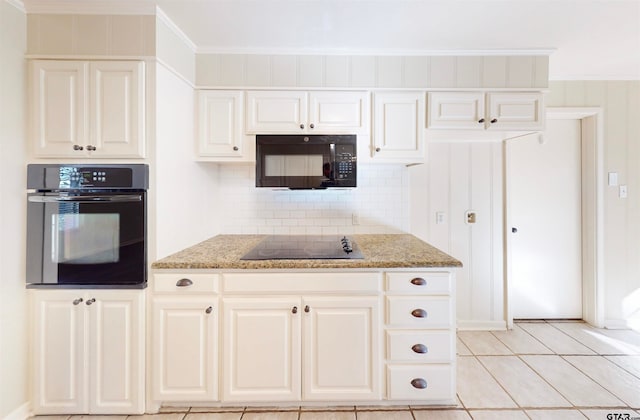 kitchen featuring decorative backsplash, crown molding, black appliances, and light stone counters