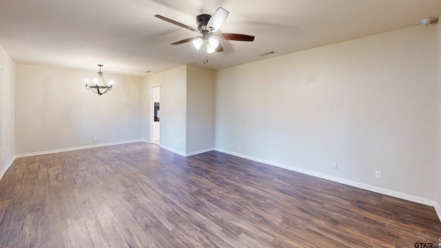 spare room featuring dark wood-type flooring and ceiling fan with notable chandelier