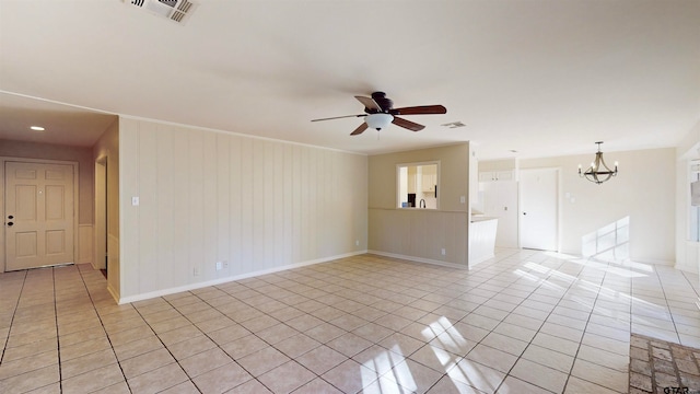 tiled spare room featuring ceiling fan with notable chandelier