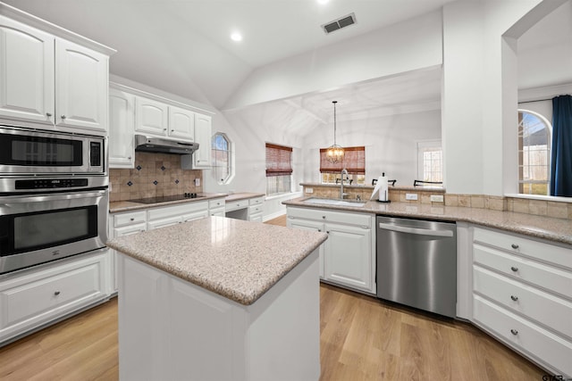 kitchen featuring sink, hanging light fixtures, stainless steel dishwasher, a kitchen island, and white cabinetry