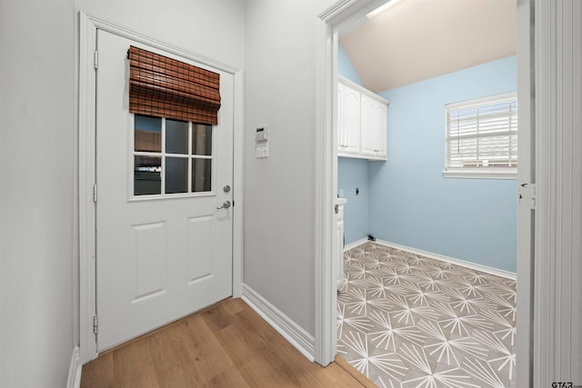 laundry area featuring light hardwood / wood-style flooring and cabinets