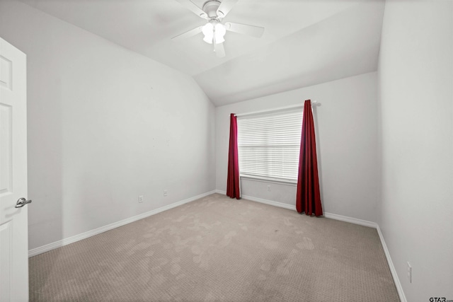 carpeted spare room with ceiling fan and lofted ceiling