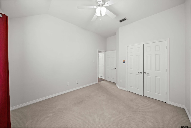 unfurnished bedroom featuring ceiling fan, lofted ceiling, light carpet, and a closet