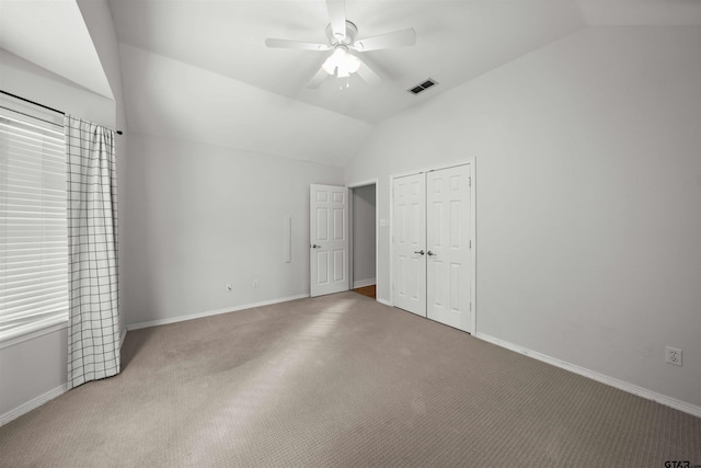 unfurnished bedroom featuring ceiling fan, carpet, and lofted ceiling