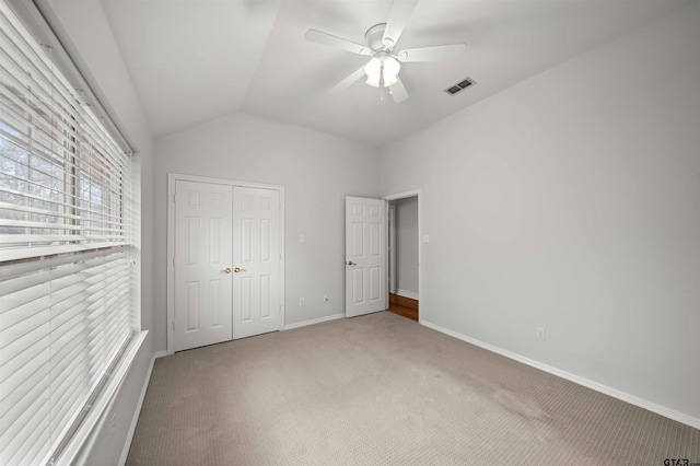 unfurnished bedroom featuring carpet, ceiling fan, lofted ceiling, and a closet