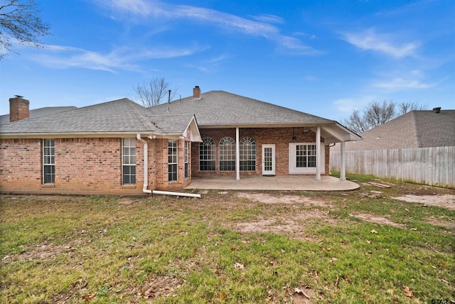 rear view of house featuring a yard and a patio area