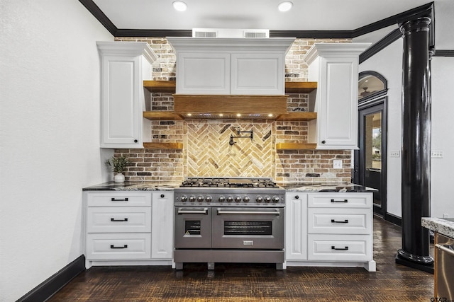 kitchen featuring range with two ovens, white cabinetry, tasteful backsplash, and dark stone counters