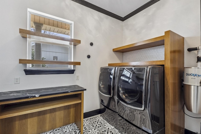 clothes washing area with ornamental molding, washer and clothes dryer, and light tile patterned floors