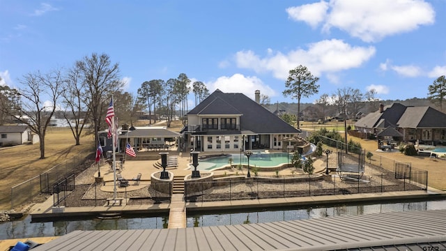 back of house featuring a fenced in pool, a patio, and a water view