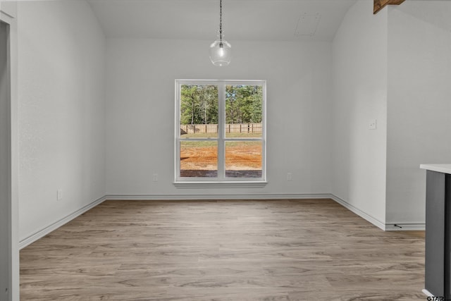 unfurnished dining area with light hardwood / wood-style flooring and lofted ceiling