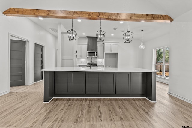 kitchen featuring decorative light fixtures, light hardwood / wood-style flooring, and a large island