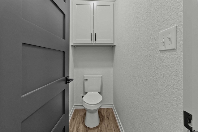 bathroom featuring wood-type flooring and toilet