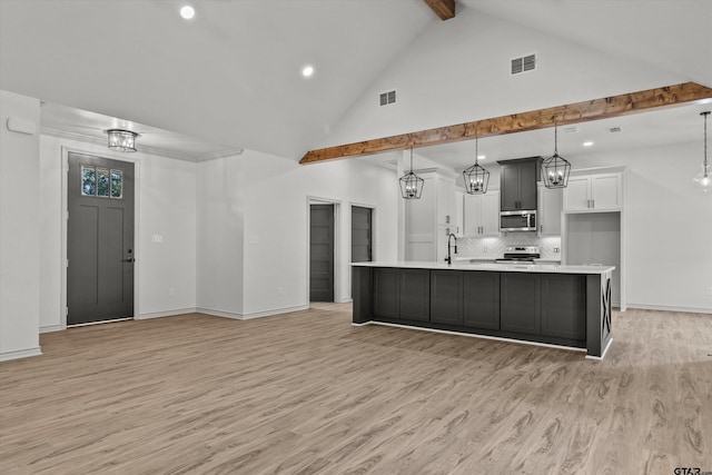 kitchen featuring a large island, hanging light fixtures, stainless steel appliances, and light hardwood / wood-style flooring