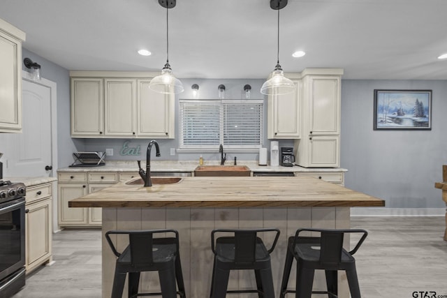 kitchen featuring stainless steel stove, a breakfast bar, and a sink