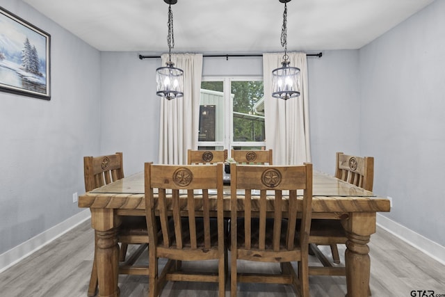dining area with an inviting chandelier, light wood-style flooring, and baseboards