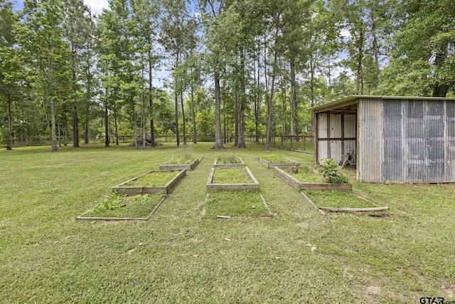 view of yard with an outdoor structure, a pole building, a garden, and fence