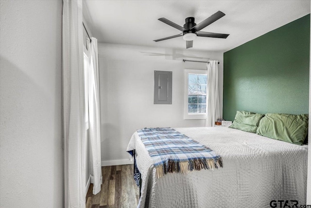 bedroom with hardwood / wood-style flooring, electric panel, and ceiling fan