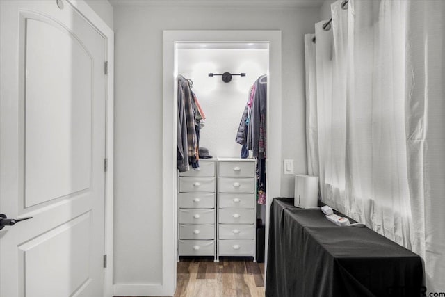 walk in closet with dark hardwood / wood-style floors