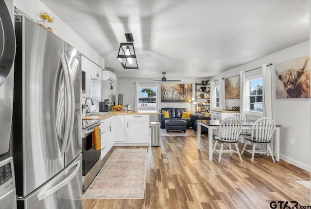 kitchen featuring white cabinetry, a healthy amount of sunlight, stainless steel appliances, and kitchen peninsula