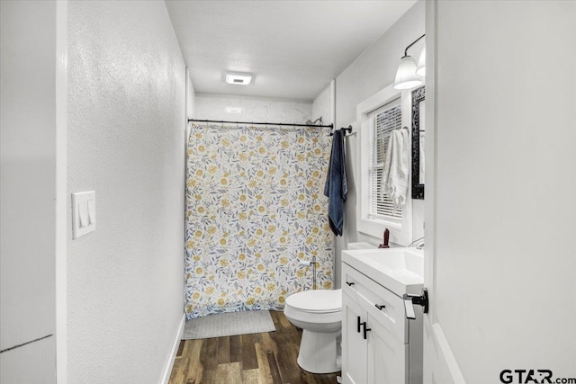 bathroom featuring vanity, hardwood / wood-style flooring, a shower with curtain, and toilet