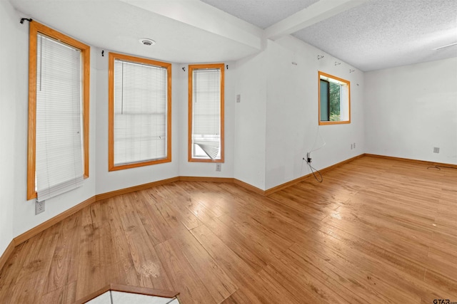 709 E Magnolia St, Troup, TX 75789 - spare room with wood-type flooring, baseboards, and a textured ceiling