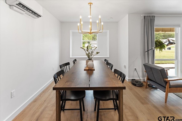 dining area with a chandelier, light hardwood / wood-style floors, and a wall mounted air conditioner