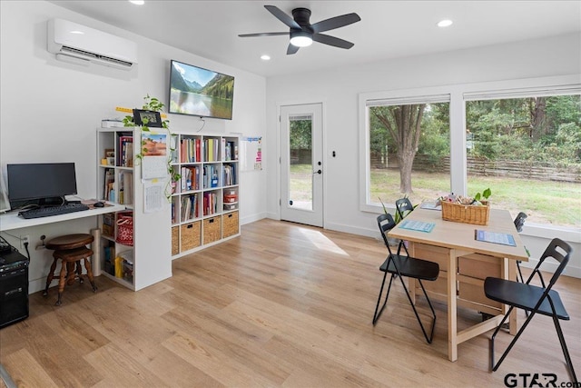 office area featuring plenty of natural light, light hardwood / wood-style floors, and a wall mounted air conditioner