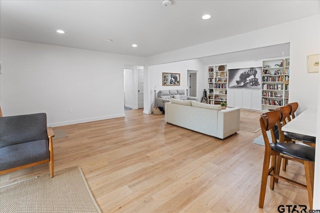 living room with light hardwood / wood-style floors and built in features