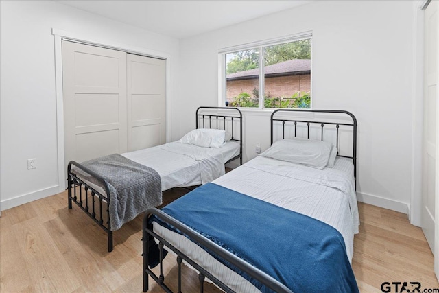 bedroom with light wood-type flooring and a closet