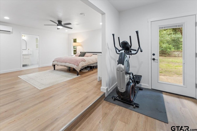 workout room featuring ceiling fan, a wall mounted AC, and light hardwood / wood-style floors