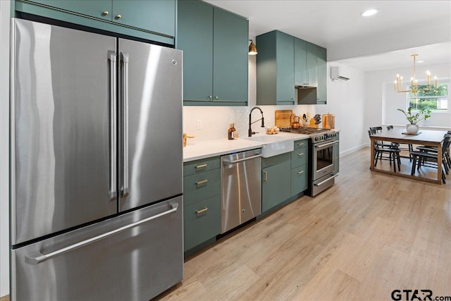 kitchen featuring a wall unit AC, sink, an inviting chandelier, light hardwood / wood-style flooring, and premium appliances