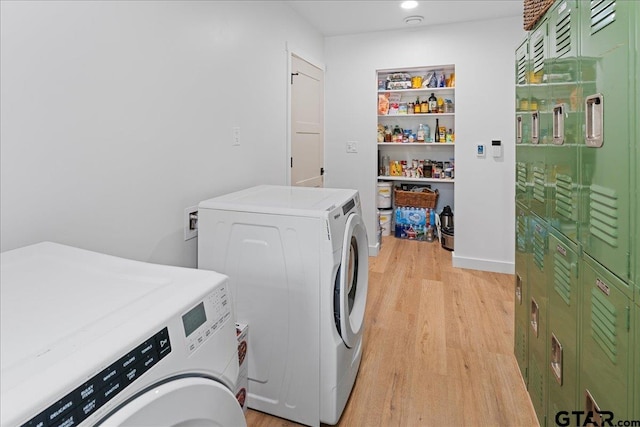 laundry area featuring washer and clothes dryer and light wood-type flooring