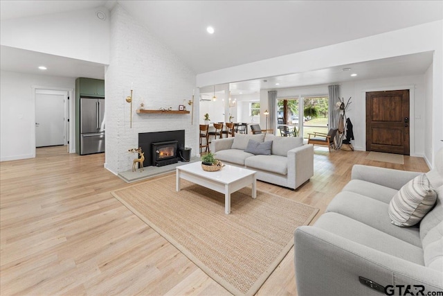 living room featuring high vaulted ceiling and light wood-type flooring