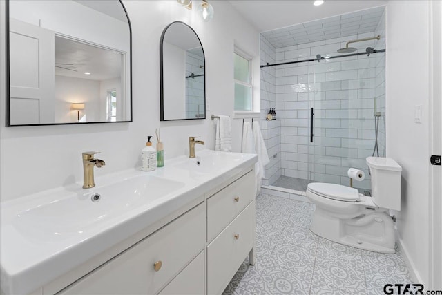 bathroom featuring a shower with shower door, vanity, tile patterned floors, and toilet