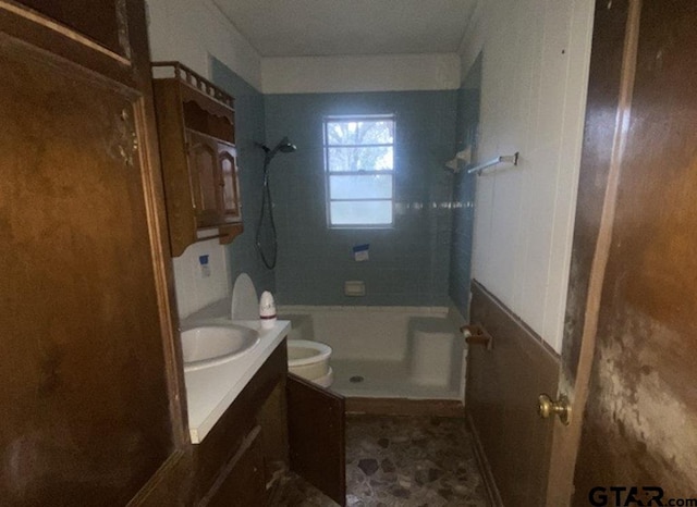 bathroom featuring tiled shower, vanity, and toilet