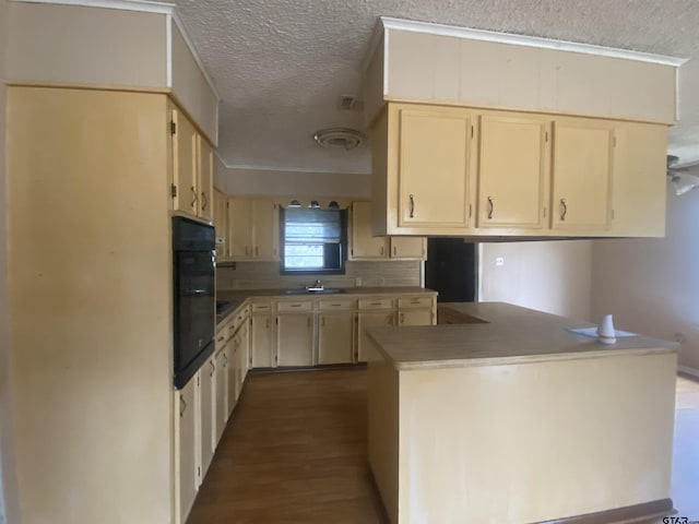 kitchen featuring tasteful backsplash, oven, dark hardwood / wood-style flooring, kitchen peninsula, and a textured ceiling