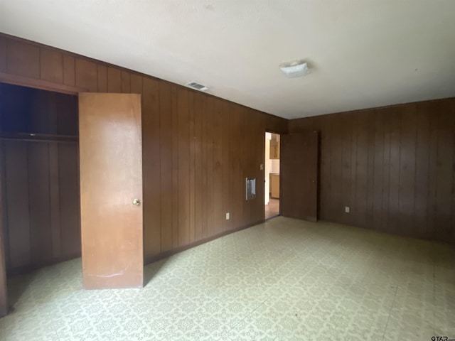 unfurnished bedroom with wood walls