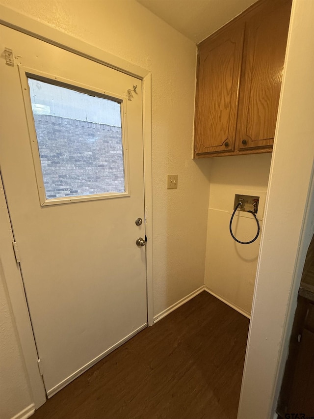 washroom with dark wood-type flooring, cabinets, and hookup for a washing machine