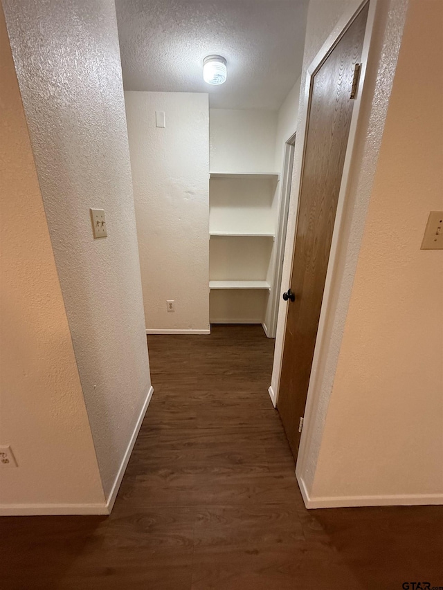 hall featuring dark hardwood / wood-style flooring and a textured ceiling